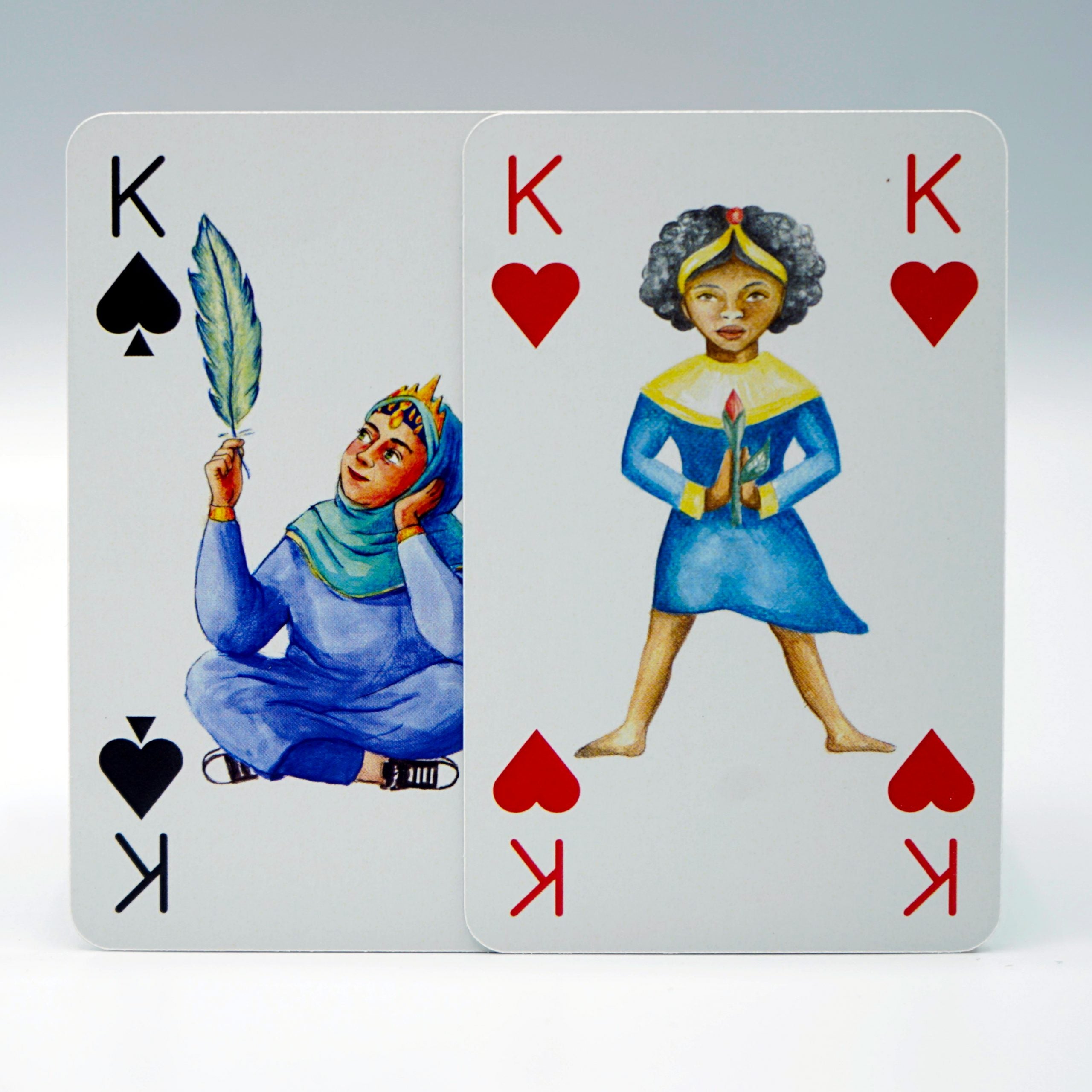 2 Spielkarten von "Spielköpfe" aus dem Kinderkarten-Set auf weißem Hintergrund. Herz Königin und Peak Königin.
