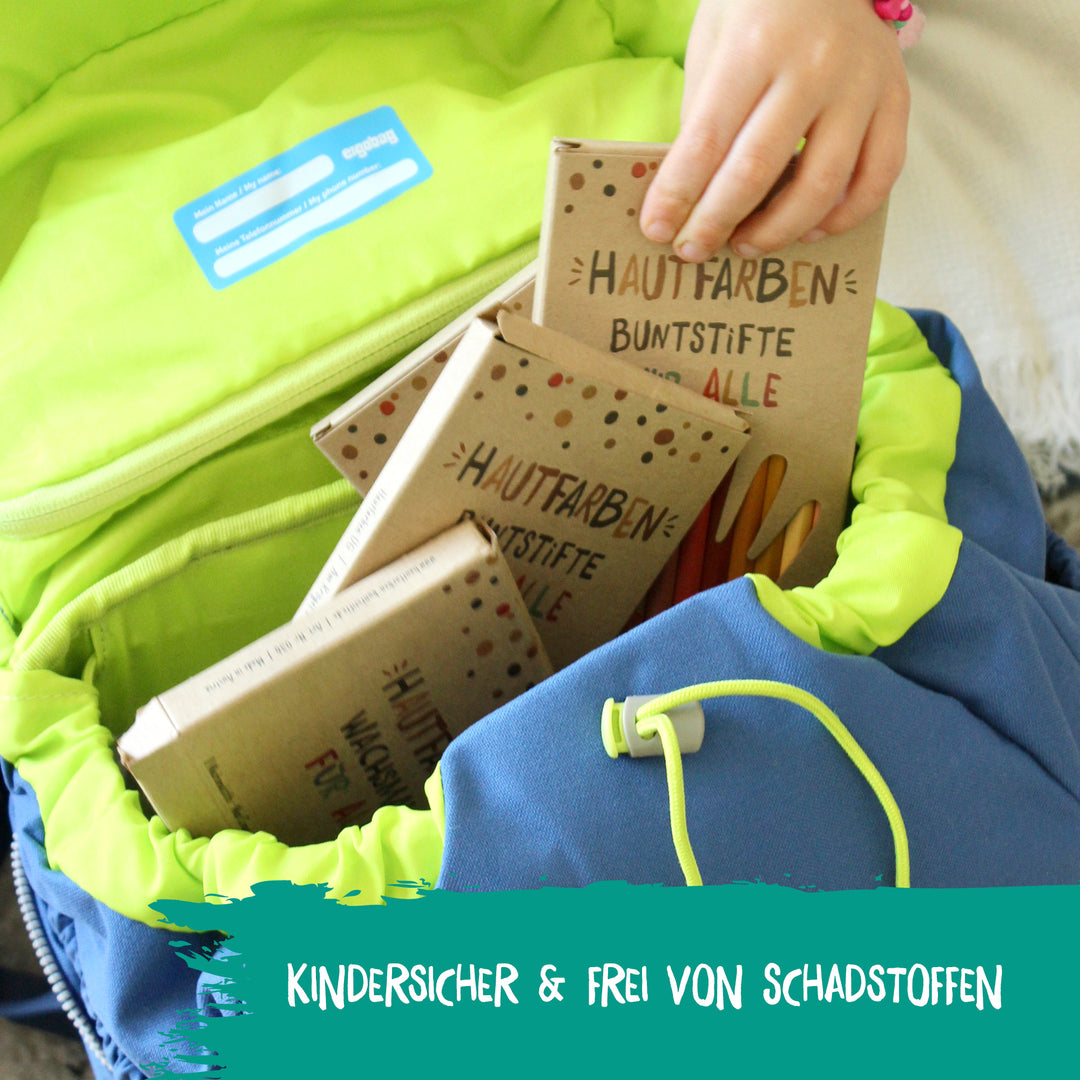 Ein Kind steckt Hautfarben-Buntstifte in den Schulranzen. Die Produkte von Hautfarben sind für Schule und Kindergarten geeignet.
