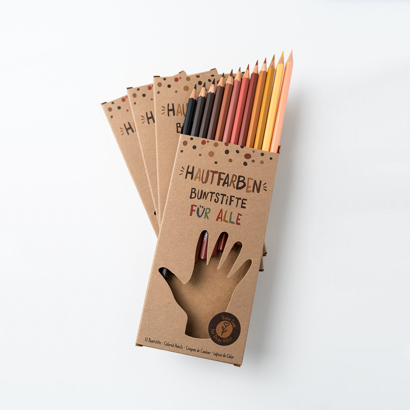 Stapel Hautfarben Buntstifte für Alle mit kompletter Verpackung und 12 verschiedenen Farbtönen die aus der oberen Verpackung herausschauen