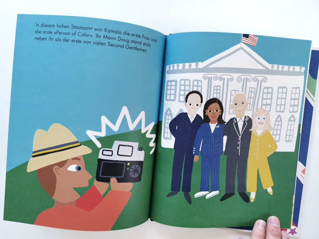 Seite aus dem Bilderbuch über "Kamala Harris". Die Illustration zeigt Kamala mit drei weiteren Menschen vor dem weißen Haus. Ein Mann fotografiert die Szene mit einer Kamera.