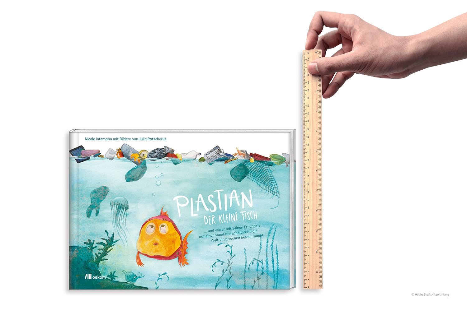Produktfoto des Kinderbuchs "Plastian der kleine Fisch" mit Lineal als Größenvergleich. Bilderbuch über Plastikmüll und Umweltschutz im Meer.